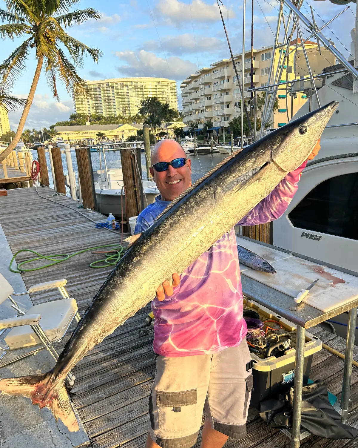 Captain Shawn holding a large wahoo on the dock at Pompano Beach